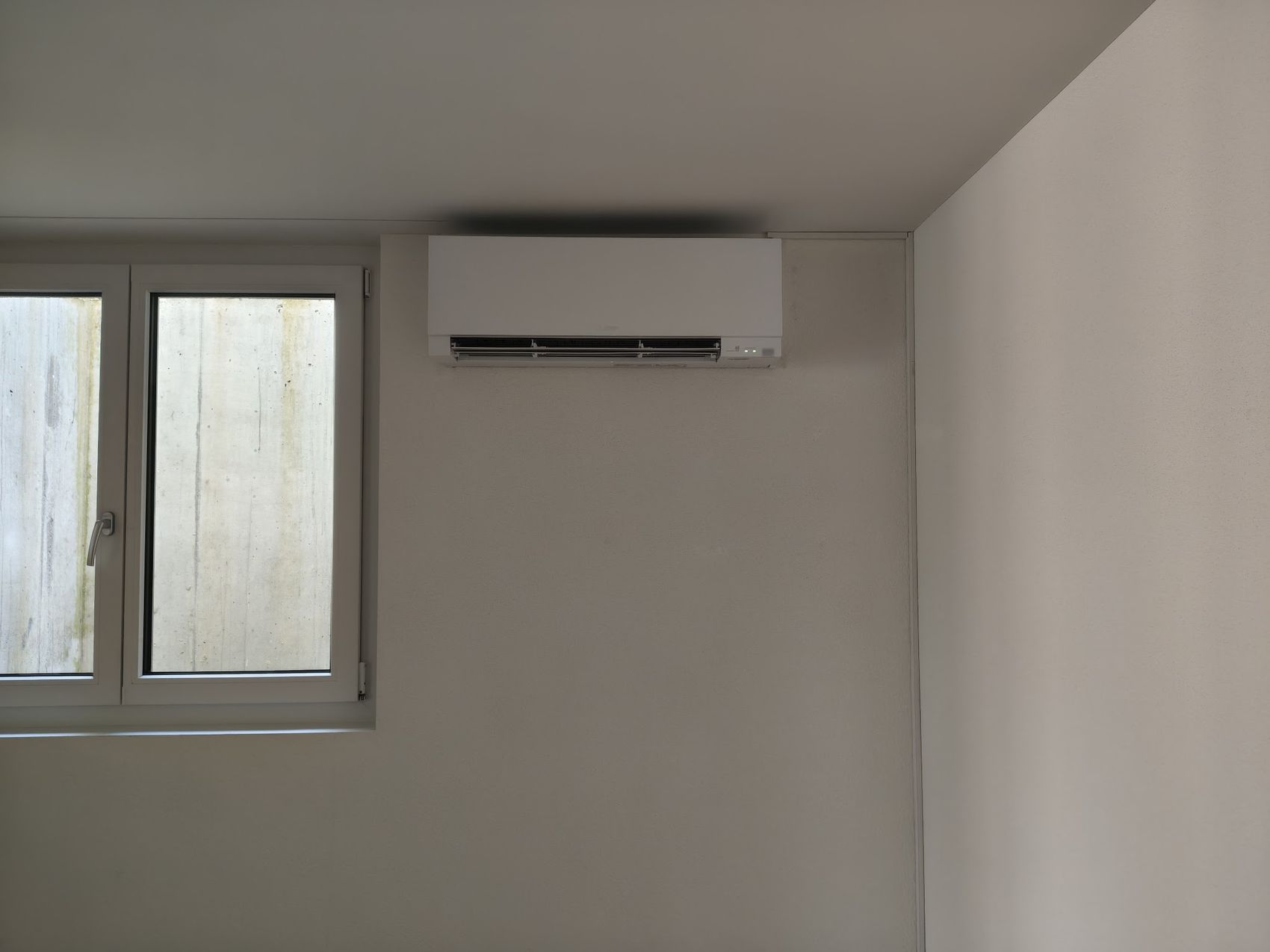 Wand-Klimagerät in einem Raum mit Fenster